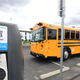 A photo of an electric school bus charging at a station.